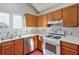 Traditional kitchen featuring wood cabinetry, white countertops, stainless steel dishwasher, and a gas stove at 245 Dennis Dr, Alpharetta, GA 30009