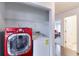 Laundry area featuring a red front-load washing machine and white top-load dryer at 245 Dennis Dr, Alpharetta, GA 30009