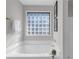 Bathroom features a white tub with glass block window and chrome fixtures at 50 Riverside Ct, Hampton, GA 30228