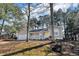 Inviting single-story home featuring a cozy front porch, set amongst mature trees at 50 Riverside Ct, Hampton, GA 30228