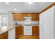 Well-lit kitchen featuring wood cabinets, white appliances, and hardwood flooring at 50 Riverside Ct, Hampton, GA 30228