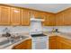 Bright kitchen featuring wood cabinetry, white appliances, and ample counter space at 50 Riverside Ct, Hampton, GA 30228