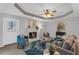 Bright living room with a white painted brick fireplace, ceiling fan, and blue accents at 50 Riverside Ct, Hampton, GA 30228