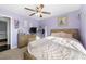 Bedroom features purple paint, ceiling fan, window with blinds and wood trimmed mirror at 1191 Fountain Head Ct, Lawrenceville, GA 30043