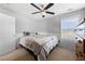 Comfortable bedroom features gray striped bedding, ceiling fan and a window with blinds at 1191 Fountain Head Ct, Lawrenceville, GA 30043