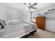 Neutral bedroom features a ceiling fan, wood dresser and gray striped bedding at 1191 Fountain Head Ct, Lawrenceville, GA 30043