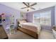 Bedroom features purple paint, ceiling fan, window with blinds and wood trimmed mirror at 1191 Fountain Head Ct, Lawrenceville, GA 30043