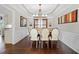 Formal dining room with tray ceilings, hardwood floors, wainscoting, and a large window at 1191 Fountain Head Ct, Lawrenceville, GA 30043