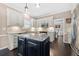 Well-lit kitchen with white cabinets, granite countertops, island, stainless steel appliances, and dark hardwood floors at 1191 Fountain Head Ct, Lawrenceville, GA 30043