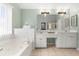 Bright main bathroom with a soaking tub, double vanities, a walk-in shower, and tile flooring at 1191 Fountain Head Ct, Lawrenceville, GA 30043