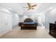 Bright main bedroom with a tray ceiling, carpet flooring, and a view of the en suite bathroom at 1191 Fountain Head Ct, Lawrenceville, GA 30043