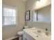 Cozy bathroom features a white vanity, framed mirror, and window with wood blinds at 5446 Oxford Chase Way, Dunwoody, GA 30338