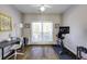 Bright bedroom featuring hardwood floors, exercise bike, desk, and a large double window at 5446 Oxford Chase Way, Dunwoody, GA 30338