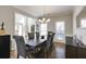 Spacious dining room with hardwood floors, a modern chandelier, and large windows providing natural light at 5446 Oxford Chase Way, Dunwoody, GA 30338