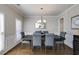 Formal dining room featuring a stylish chandelier, ample natural light, and elegant trim work at 5446 Oxford Chase Way, Dunwoody, GA 30338