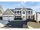 Charming two-story home with a well-manicured lawn and a two-car garage, all under a clear blue sky at 5446 Oxford Chase Way, Dunwoody, GA 30338