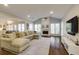 Open living room featuring hardwood floors, fireplace, large sofa, and ample natural light at 5446 Oxford Chase Way, Dunwoody, GA 30338