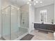 This is a bathroom featuring a large glass shower with gray tile, modern light fixture, and gray cabinets at 574 Boulevard Ne Pl # 5, Atlanta, GA 30308