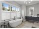 Bright bathroom featuring a soaking tub under a window, vanity with white countertops, and gray cabinets at 574 Boulevard Ne Pl # 5, Atlanta, GA 30308