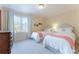 Light-filled bedroom with twin beds, pink accents, and a wooden dresser at 78 Paces West Nw Cir, Atlanta, GA 30327