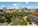 Picturesque aerial view of a community featuring a tranquil pond, walking paths, and modern urban buildings at 375 Highland Ne Ave # 908, Atlanta, GA 30312