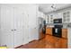 Kitchen area with stainless refrigerator, hardwood flooring, and white cabinetry with glass accents at 375 Highland Ne Ave # 908, Atlanta, GA 30312