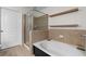 Bathroom featuring a glass-enclosed shower, a soaking tub, and neutral tile at 390 17Th Nw St # 1063, Atlanta, GA 30363