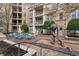 Beautiful courtyard with blue chairs and tables, modern sculpture, and easy access to resident balconies at 390 17Th Nw St # 1063, Atlanta, GA 30363