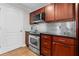 Kitchen with stainless steel appliances, cherry wood cabinets, and black countertops at 390 17Th Nw St # 1063, Atlanta, GA 30363