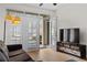 Comfortable living room featuring an open door to the patio with a modern TV and floral decorated cabinet at 390 17Th Nw St # 1063, Atlanta, GA 30363