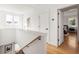 Upstairs hallway with hardwood floors and white trim, leading to a bedroom with natural light at 56 Walthall Ne St, Atlanta, GA 30307