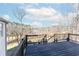 An outdoor deck with wooden railings, offers a scenic view of the surrounding trees and landscape at 8160 Stone Hill Rd, Cumming, GA 30028