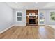 Open-concept living room featuring a stone fireplace, wood-look flooring, and a glass door at 9377 Woodloop Ct, Jonesboro, GA 30238