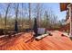 Backyard with a large wooden patio, furniture, umbrellas, and a hot tub providing a relaxing space at 1617 Matt Springs Dr, Lawrenceville, GA 30045