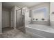 Inviting bathroom featuring a soaking tub, a walk-in shower, and neutral tiling at 1617 Matt Springs Dr, Lawrenceville, GA 30045