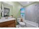 Traditional bathroom with white sink, toilet, shower-tub combo with decorative curtain, and tiled walls at 1617 Matt Springs Dr, Lawrenceville, GA 30045