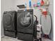 Functional laundry room with front loading washer and dryer, storage, and ironing equipment at 1617 Matt Springs Dr, Lawrenceville, GA 30045