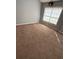 Bedroom with plush carpeting, gray walls, and a large window with sunlight at 2372 Johnson Rd, Atlanta, GA 30345