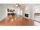 Open concept living room featuring a fireplace, hardwood floors, and a view of the kitchen and screened porch at 2418 Caylor Hill Pte Nw, Kennesaw, GA 30152