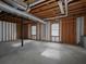 Unfinished basement space showcasing exposed ceiling, concrete floor, and natural light from the windows at 53 Carrington Lndg, Douglasville, GA 30134