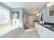 Bright bathroom featuring tile floors, white cabinets with dark countertops, and a large soaking tub at 8340 Nolandwood Ln, Villa Rica, GA 30180
