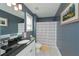 Bathroom with gray walls, a framed mirror, and a patterned shower curtain near the vanity at 8340 Nolandwood Ln, Villa Rica, GA 30180