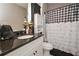 Bathroom features a granite countertop, white cabinets and a charming checkered shower curtain at 8340 Nolandwood Ln, Villa Rica, GA 30180
