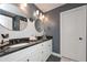 Well lit bathroom featuring double sinks, granite countertop, and herringbone tile backsplash at 8340 Nolandwood Ln, Villa Rica, GA 30180