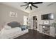 Cozy bedroom with a tufted headboard, sliding barn door media console, and a large ceiling fan at 8340 Nolandwood Ln, Villa Rica, GA 30180