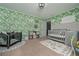 Well-decorated Bedroom with leaf-print wallpaper, a crib, and a play area with carpeted floor at 8340 Nolandwood Ln, Villa Rica, GA 30180