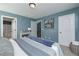 Bedroom with blue walls, plush carpet, and a comfortable bed with a blue throw blanket at 8340 Nolandwood Ln, Villa Rica, GA 30180