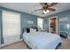 Comfortable bedroom featuring blue walls, ceiling fan, and ample natural light at 8340 Nolandwood Ln, Villa Rica, GA 30180