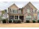 Charming two-story home featuring stone accents, neutral siding, and a welcoming front porch with rocking chairs at 8340 Nolandwood Ln, Villa Rica, GA 30180