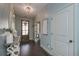 Elegant foyer with a stylish light fixture, wooden door, and views into other rooms, enhancing the home's charm at 8340 Nolandwood Ln, Villa Rica, GA 30180
